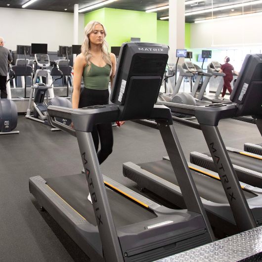 Young gym member at 10GYM Broken Arrow, OK, walking on a treadmill for cardio training