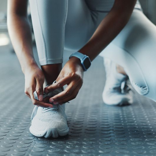 a member at 10GYM Broken Arrow, Oklahoma, tying shoes before a walk on the indoor track