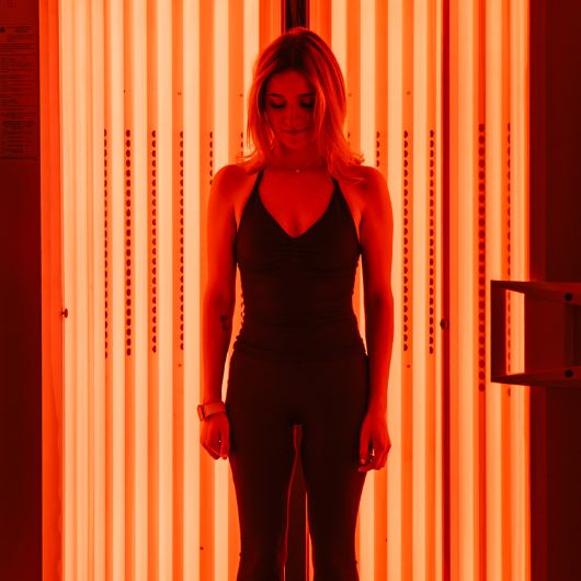 Person standing inside the Beauty Angel red light therapy booth at 10GYM Broken Arrow.