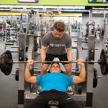 personal trainer working with gym member in modern gym in Broken Arrow