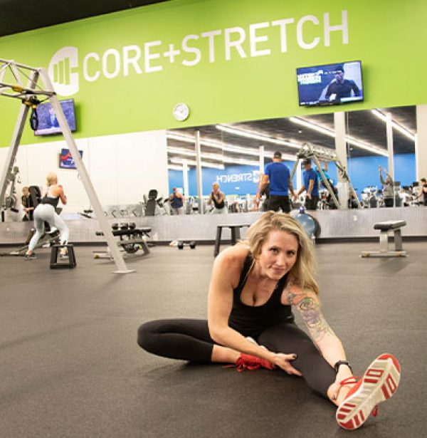 woman stretching in dedicated stretching area at gym in tulsa