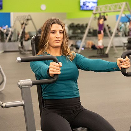 Woman working out with weights in gym in Edmond