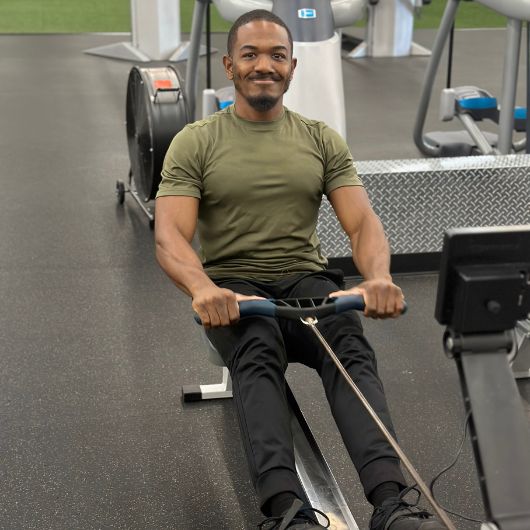 Member using the rowing machine in the cardio area at 10GYM Jenks to highlight the gym’s cardio equipment and training options.
