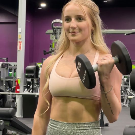 Member doing dumbbell curls in the strength training area at 10GYM Jenks.