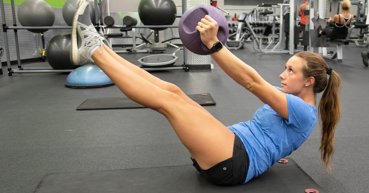woman working on her core with bosu ball