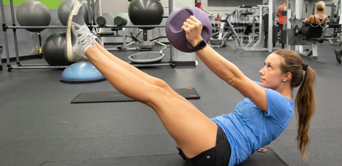 woman doing a core workout with ball