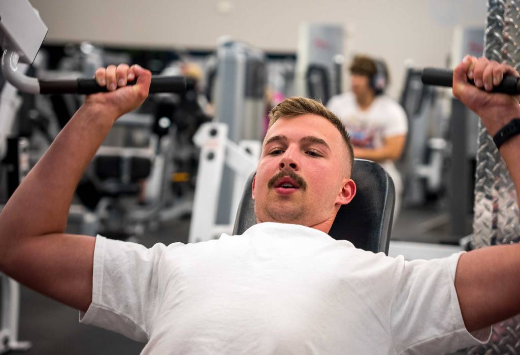 a gym member at 10gym owasso works out in the strength training area equipped with free weights and resistance machines