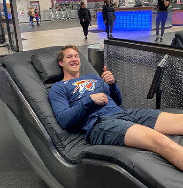 man using hydromassage chair to recover from workout.