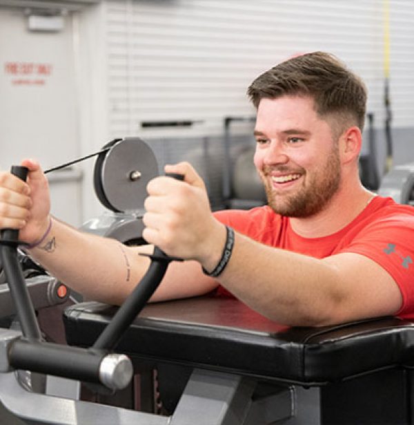 man using a workout machine in a modern gym
