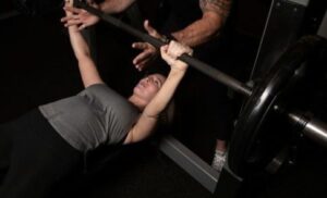 woman lifting weights with spotter at gym near me