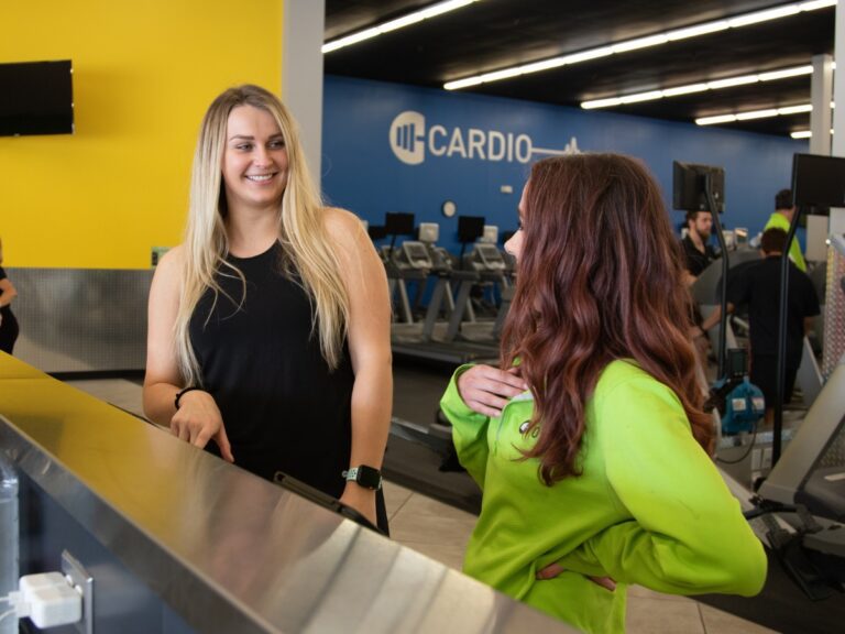 a gym member chats with a 10gym team member at a gym near me in oklahoma