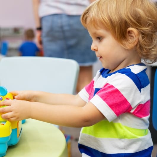 a kid plays with a toy in the kids fun zone onsite childcare at 10gym in oklahoma