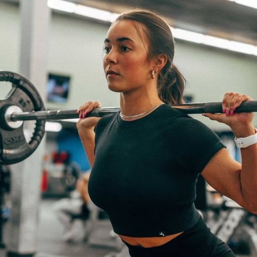 a gym member uses free weights for strength training at a 10gym location near me