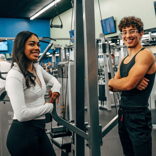 2 gym members pose for a photo between sets of strength training at 10gym near me