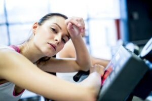 Woman resting on a treadmill during a workout at our Oklahoma and Arkansas gyms.